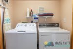 Washer and dryer with detergents, iron and board for guest use. Alongside a beach blanket.